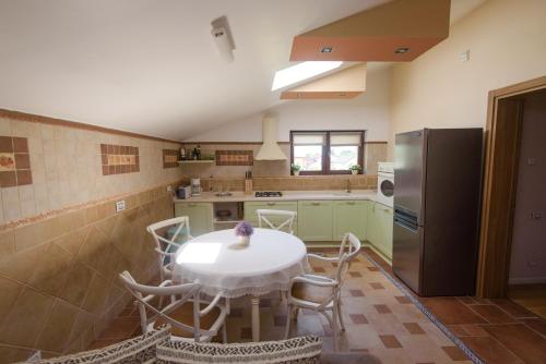 a kitchen with a table and a refrigerator at Vila Ramona in Otopeni