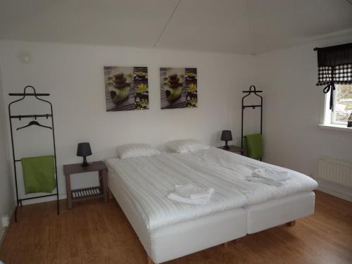a bedroom with a white bed and three pictures on the wall at Gamla Bryggeriet Bed & Breakfast in Köpingsvik