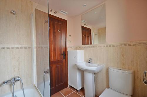 a bathroom with a sink and a toilet and a mirror at Hacienda del Alamo Golf in Fuente Alamo