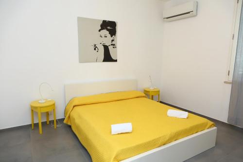 a bedroom with a yellow bed and two tables at casa verdemare in Cefalù