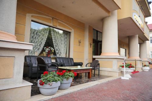 a building with chairs and a table and flowers in a window at Hotel Ten Constanta in Constanţa