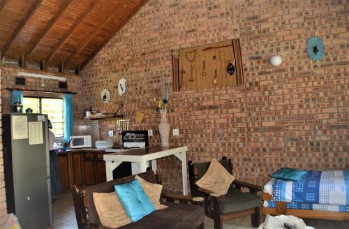 a room with a brick wall and a table and chairs at St Lucia Wilds in St Lucia