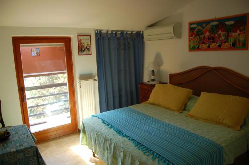 Schlafzimmer mit einem Bett und einer Glasschiebetür in der Unterkunft Le Coin Vert in Fregene