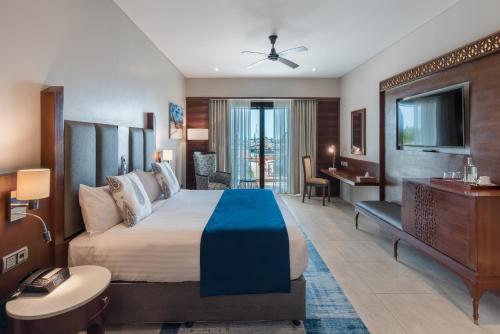 Pokój hotelowy z dużym łóżkiem i telewizorem w obiekcie Hotel Verde Zanzibar - Azam Luxury Resort and Spa w mieście Zanzibar