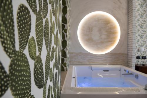 La salle de bains est pourvue d'une baignoire avec une lune sur le mur. dans l'établissement Agriturismo Il Granaio Hotel & SPA, à Modica