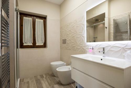 a bathroom with a sink and a toilet and a mirror at Agriturismo Il Granaio Hotel & SPA in Modica