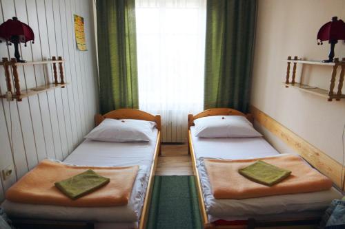 two beds in a small room with a window at Willa Jasna in Czorsztyn