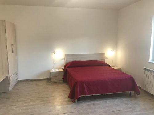 a bedroom with a bed with a red blanket on it at vecchio frantoio in Spezzano Albanese