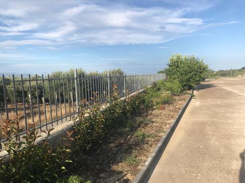 a fence next to a road next to some plants at vecchio frantoio in Spezzano Albanese