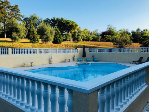 a swimming pool on a balcony with a white fence at Château Logis de Roche in Clairac