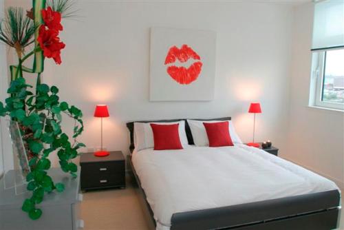 a bedroom with a bed with two lamps and a plant at River Clyde West End Apartment - 2 Bedrooms in Glasgow