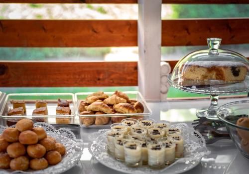 a table topped with trays of pastries and pies at Sunday Hotel in Ialyssos