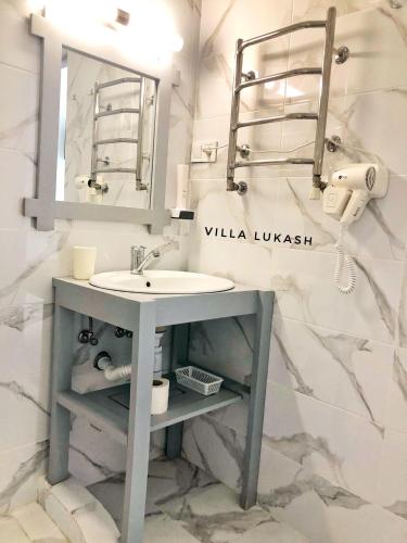 a bathroom with a sink and a mirror at Villa Lukash in Yanoshi