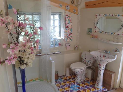 カロにあるla maison bleueのバスルーム(トイレ、洗面台、花瓶付)