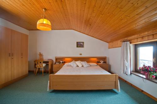 ein Schlafzimmer mit einem Bett und einer Holzdecke in der Unterkunft Albergo Negritella in Borgo