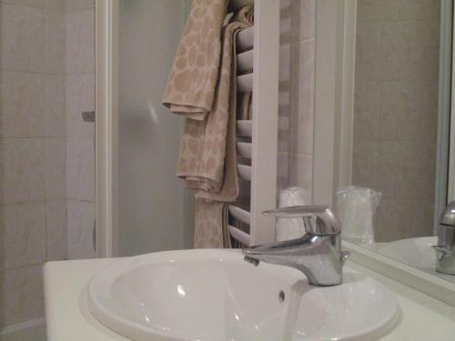 a bathroom with a sink and a shower with towels at Auberge "AU BON ACCUEIL" in Crouzilles