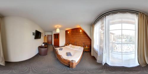 a bedroom with a bed and a large window at Dworek Pod Jodłami in Zakopane
