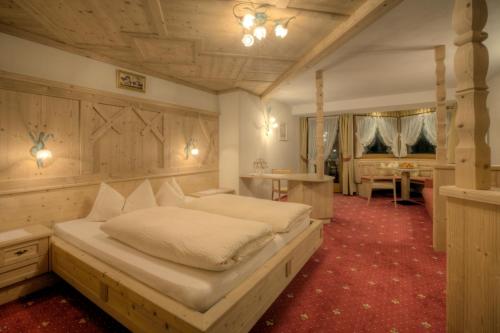 Ένα ή περισσότερα κρεβάτια σε δωμάτιο στο Hotel Ciasa Ai Pini