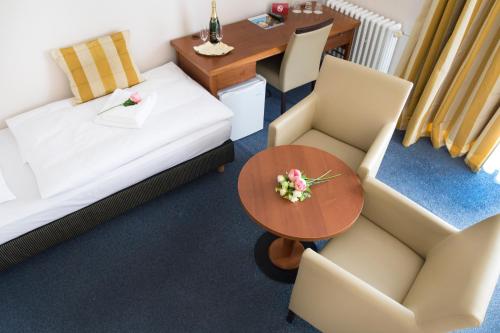 a living room with a table and two chairs and a table and a couch at Hotel Marttel in Karlovy Vary