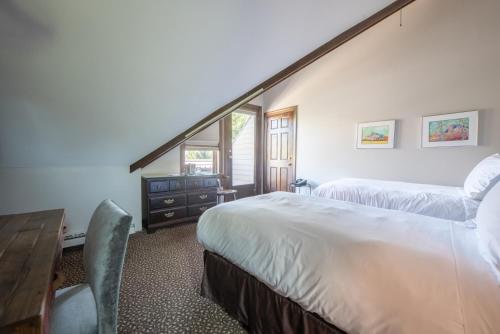 a bedroom with two beds and a table and a desk at Elk Mountain Lodge in Crested Butte