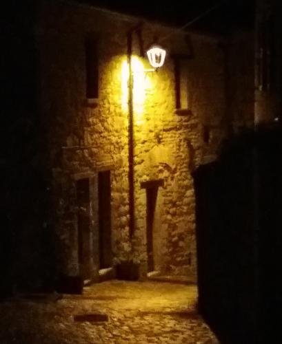 a street light on the side of a building at night at Albergo Montenerone in Piobbico