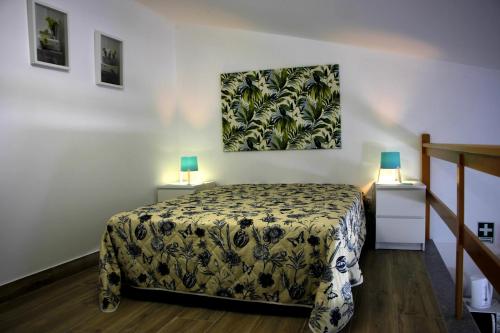 ゴーイスにあるCasa da Avó Olindaのベッドルーム1室(ベッド1台、ランプ2つ、テーブル2台付)