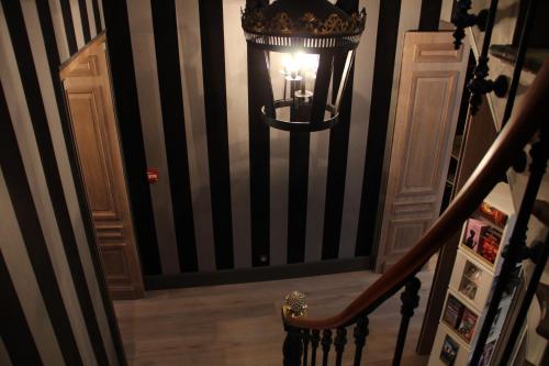 a hallway with a staircase with a light on the wall at Villa Glamour in Paris