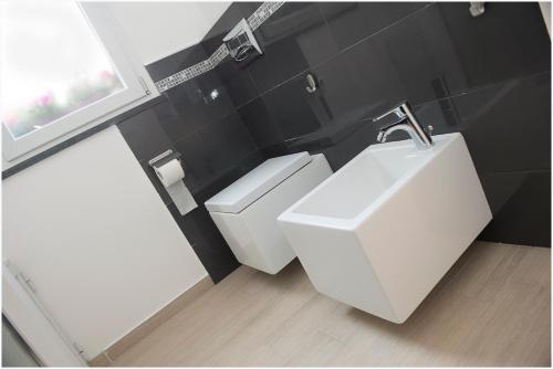 a bathroom with a white sink and a toilet at Dolce Vita in Zafferana Etnea