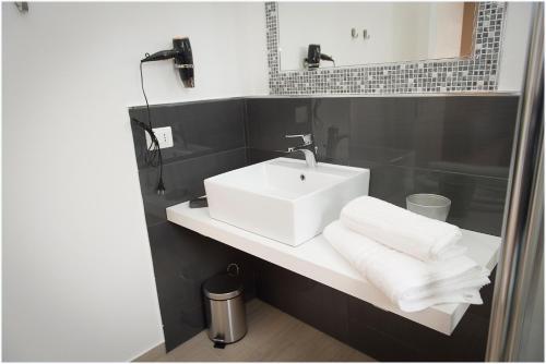 a bathroom with a white sink and a mirror at Dolce Vita in Zafferana Etnea