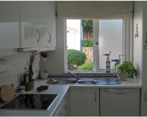フェラグドにあるOcean Terraces Vila Gaivota Hの白いキッチン(シンク付)、窓