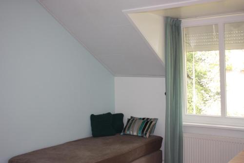 a room with a window and a couch and a window at Hotel De Hoefpoort in Gemert