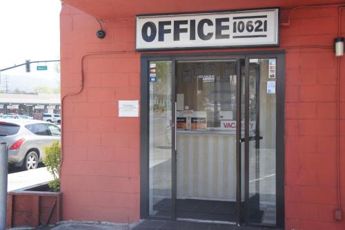 an office sign on the side of a red brick building at Budget Inn in El Cerrito