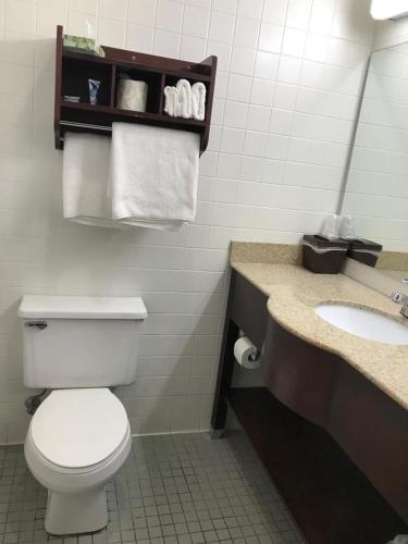 a bathroom with a toilet and a sink with towels at CCI Express Inn in Central City