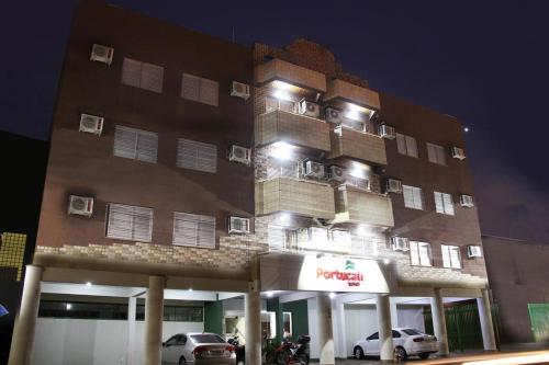 un gran edificio con coches estacionados frente a él en Hotel Portucali, en Ribeirão Preto