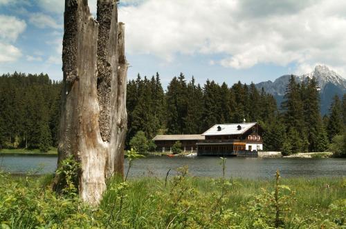 a house on the shore of a lake at Alpenmotel Säuling in Reutte