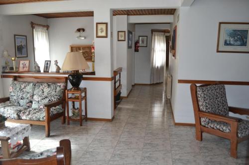 sala de estar con sofá y 2 sillas en Hostal Rio Ona en Ushuaia