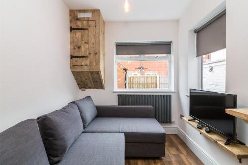 a living room with a couch and a tv at Salisbury Street Guesthouse in Long Eaton