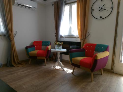 une chambre avec trois chaises, une table et une horloge dans l'établissement Résidence Hélène Boucher - Idéal entre Aéroport Paris Orly et Paris Centre 20mn, à Villeneuve-Saint-Georges