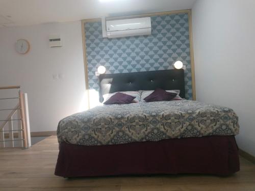 1 dormitorio con 1 cama con pared azul en Résidence Hélène Boucher, en Villeneuve-Saint-Georges