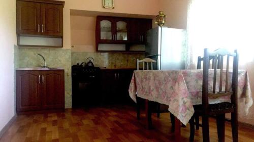cocina con mesa y nevera en Мзетамзе 59, en Borjomi