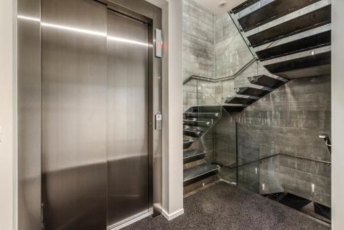 a hallway with a metal elevator and a staircase at Diamond Deluxe Central Queenstown in Queenstown