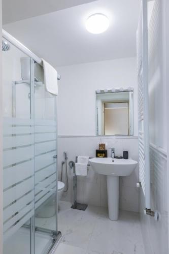 a white bathroom with a sink and a mirror at VRooms All'Angolo Del Duomo in Florence