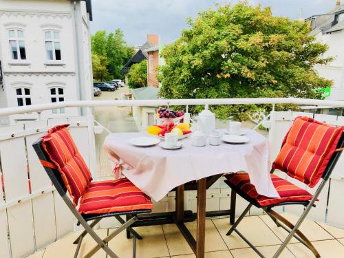 een tafel en 2 stoelen op een balkon bij Suite Boysen No.15 in Westerland