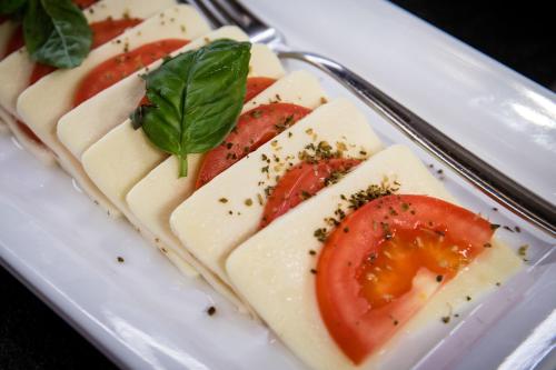 a plate of food with tomatoes and cheese at Hotel Klostersepp in Chiusa