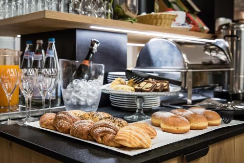 a table with a bunch of donuts on a counter at Hotel Klostersepp in Chiusa