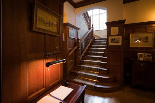 a hallway with a staircase in a house at Lindeth Fell Country House in Bowness-on-Windermere