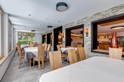 a restaurant with tables and chairs and a brick wall at Hotel Klostersepp in Chiusa