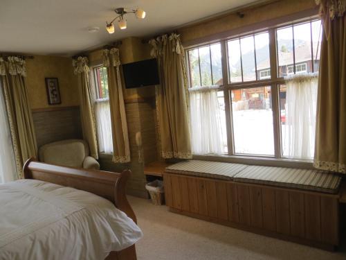 a bedroom with a bed and a large window at Buffaloberry Bed & Breakfast in Banff
