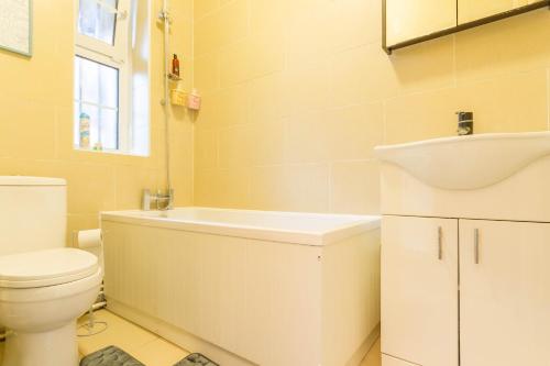 a bathroom with a toilet and a tub and a sink at The Hideaway in London in London