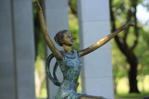 a bronze statue of a woman with her arms in the air at The Lorian Club in Cocoyoc